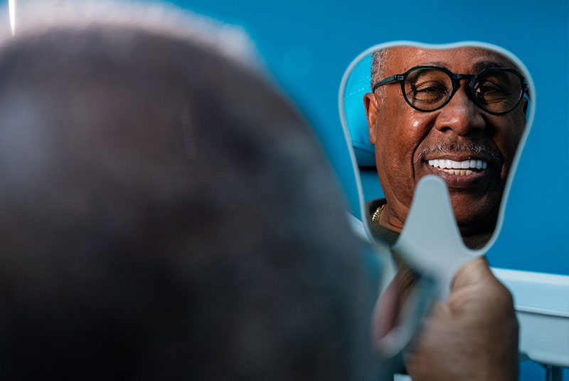 Patient smiling after completing dental implant care