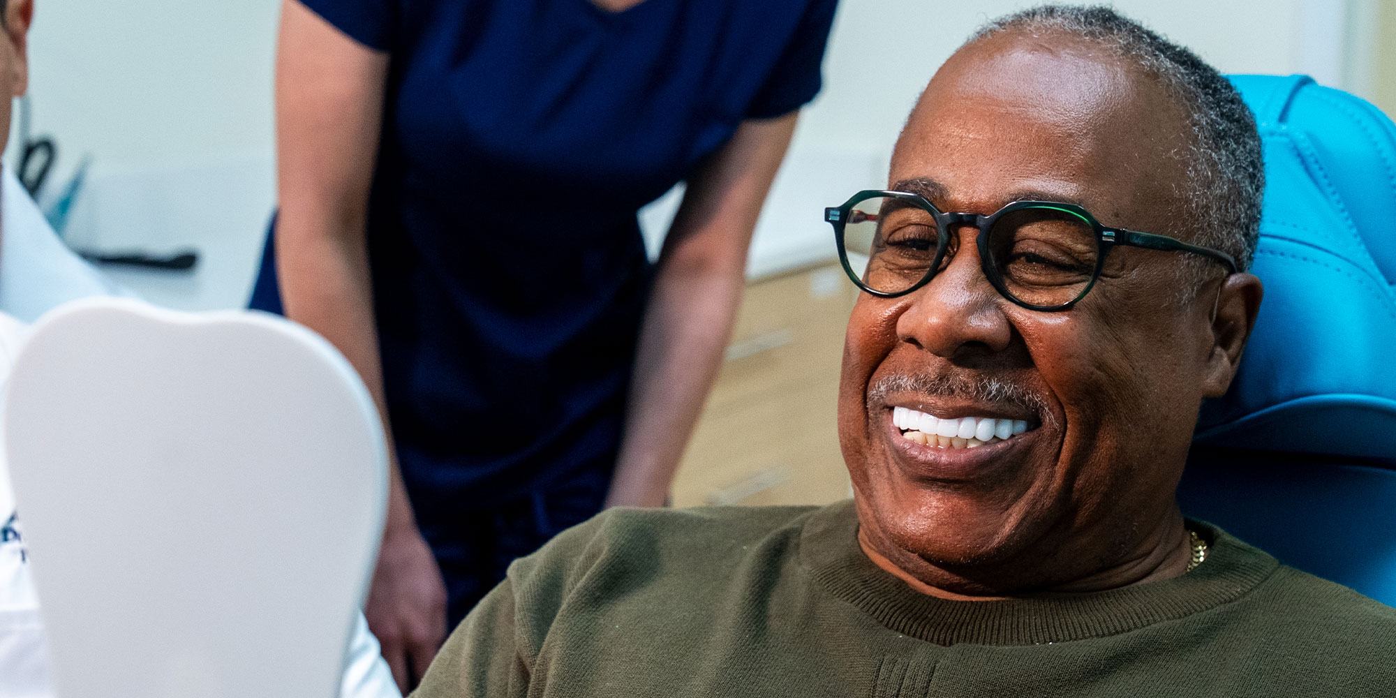 Patient smiling after receiving dental implant treatment