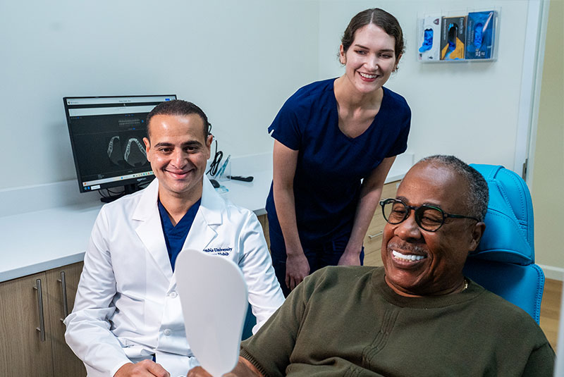 patient and doctor and staff member all smiling brightly after the patent's successfull treatment
