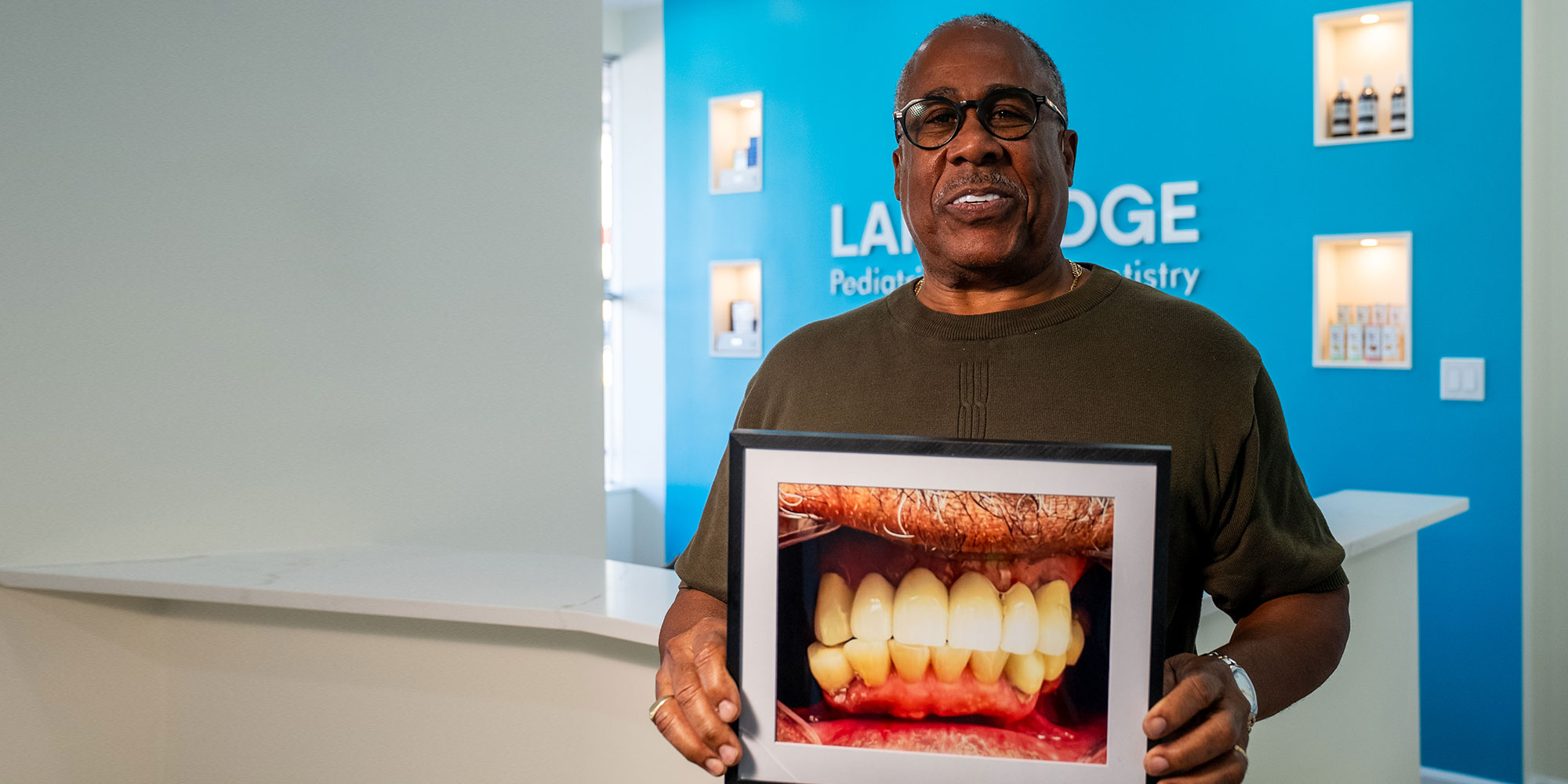 patient smiling while holding their before procedure treatment